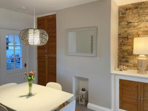 a dining room with a vase of flowers on a table at Harbour Walk in Amble