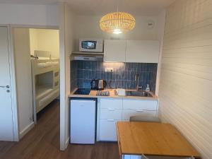 a small kitchen with a sink and a microwave at Appartements rénovés vue golf in Anglet +8 photos
