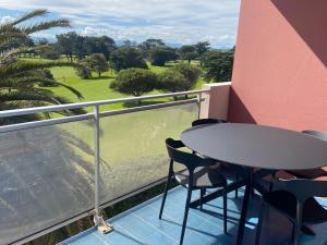 a balcony with a table and chairs and a golf course at Appartements rénovés vue golf in Anglet