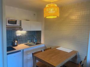 a small kitchen with a table and a microwave at Appartements rénovés vue golf in Anglet