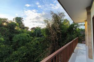 balcón con vistas a los árboles y arbustos en Bhuana Shanti Homestay, en Ubud