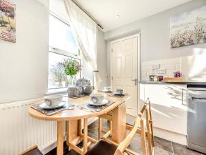 a kitchen with a small wooden table in a kitchen at East Llwyn - Uk41756 in Rhyd Owen