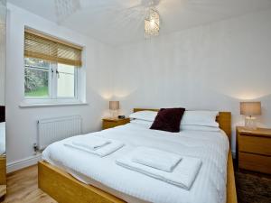 Un dormitorio con una cama grande con sábanas blancas y una ventana. en 3 Harbour View, en Newquay 7 fotos más