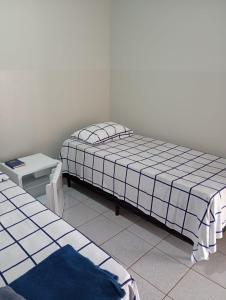 a small bedroom with a bed and a table at Hotel Vale do Sol in Valparaíso