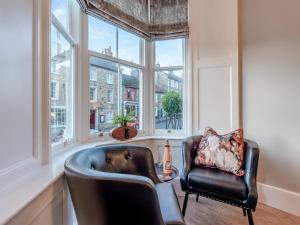 a living room with two chairs and windows at Old Bank House in Barnard Castle
