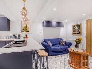 eine Küche und ein Wohnzimmer mit einer blauen Couch in der Unterkunft The Pantiles in Chesterfield