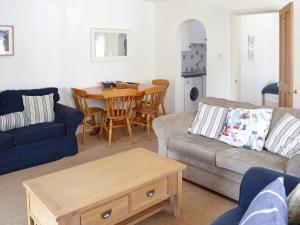 ein Wohnzimmer mit Sofa und Tisch in der Unterkunft Stonehanger 1 - Cottage in Salcombe