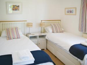 2 Einzelbetten in einem Zimmer mit einem Tisch in der Unterkunft Stonehanger 1 - Cottage in Salcombe + 2 Fotos