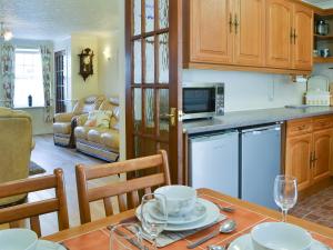 Una cocina y una sala de estar con mesa y sillas. en Jackdaw House, en Bridlington