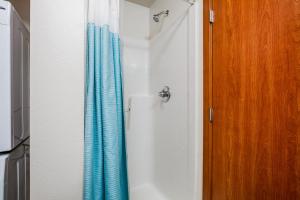 a bathroom with a blue shower curtain next to a door at Blueground Brighton balcony nr Othello Park SEA-875 in Seattle +28 photos