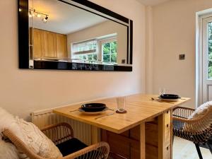 - une table à manger avec un miroir mural dans l'établissement Modern 2-Bed Home with great location in Luton, à Luton 5 autres photos