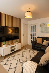 un salon avec un canapé et une télévision à écran plat dans l'établissement Modern 2-Bed Home with great location in Luton, à Luton