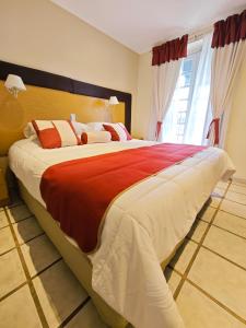 a large bed in a bedroom with a large window at Hotel Francia in Tandil
