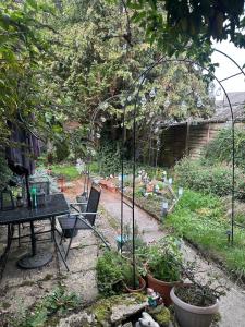 un jardín con mesa y sillas y un invernadero en 2 bedrooms self contain flat with nice garden, en Didcot