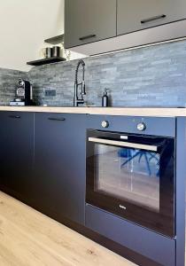 a kitchen with a black oven and a sink at Mellie's Ferienwohnung im Stryck in Willingen