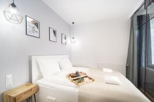 a bedroom with a bed with a tray on it at Browar Gdański Superior Apartments by Noclegi Renters in Zaspa