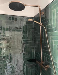 a shower in a bathroom with green tiles at Mellie's Ferienwohnung im Stryck in Willingen