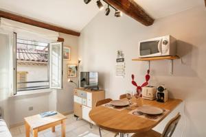 a kitchen with a table with a microwave on the wall at Duplex au cœur du vieil Antibes, Le Jamesy in Antibes +3 photos