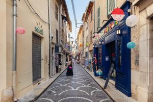 a woman walking down a street in an alley at Duplex au cœur du vieil Antibes, Le Jamesy in Antibes