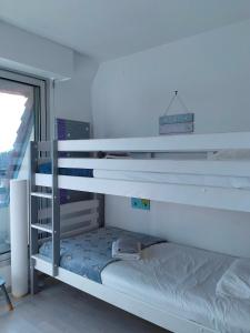 Letto a castello bianco in una camera con finestra di Joli appartement familial, 2 chambres, calme et soleil a Cabourg
