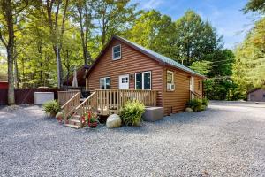 a log cabin with a porch and a driveway at Owl's Nest in Broadalbin
