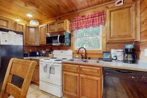 eine Küche mit weißem Herd und Spüle in der Unterkunft Black Bear Hideaway Cabin in Gatlinburg