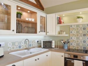 a kitchen with a sink and a microwave at Calf House Cottage in Sedgefield +12 photos