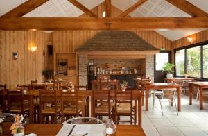 a dining room with wooden tables and chairs at Logis Hôtel restaurant La Remise in Le Bleymard