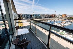 ein Balkon mit zwei Stühlen und Blick auf einen Hafen in der Unterkunft Hestia Hotel Europa in Tallinn