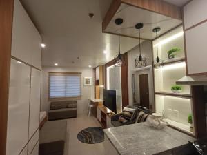 a kitchen and living room with a table and a couch at Plumera Mactan near Airport in Bankal