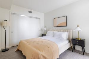 a white bedroom with a bed and a lamp at Blueground Downtown Berkeley rooftop nr UC Berkeley SFO-1954 in Berkeley +26 photos