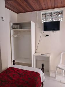 Un dormitorio con una cama y un televisor de pantalla plana. en Hotel Pousada Acácia da Barra, en Salvador