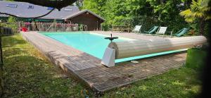 einen Pool mit einer Bank und einer Holzterrasse in der Unterkunft Villa D'Andy - Collection Idylliq in Paron