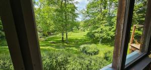 ein Fenster mit Blick auf ein üppiges grünes Feld mit Bäumen in der Unterkunft Villa D'Andy - Collection Idylliq in Paron