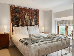 a bedroom with a large bed with towels on it at Bonsall View Cottage in Bonsall