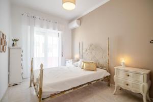 a white bedroom with a bed and a dresser at HolidaysPT - CrisMarco apartment Olhão in Olhão