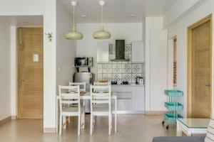 a kitchen with a table and chairs in a room at Tastefully Done 1BHK Apartment by tisyastays in Candolim