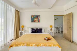 a bedroom with a large bed with a tray on it at Tastefully Done 1BHK Apartment by tisyastays in Candolim +18 photos