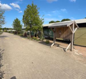 a building with a bench next to a street at Chalet op park Kniphorst in Anloo