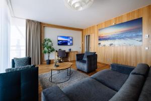 ein Wohnzimmer mit einer Couch, zwei Sesseln und einem Tisch in der Unterkunft Hestia Hotel Europa in Tallinn