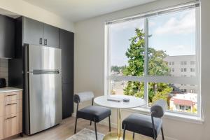 a kitchen with a table and a refrigerator and a window at Blueground Meridian Park view nr Shoreline Park SEA-932 in Shoreline +25 photos