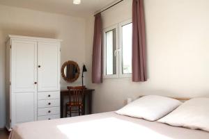 a bedroom with a white bed and a window at Casa a Rudas in Alghero