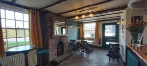 a living room with a fireplace and tables and chairs at The Blacksmiths Arms in Halland