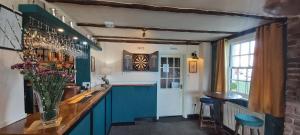 a bar with blue cabinets and a vase of flowers at The Blacksmiths Arms in Halland