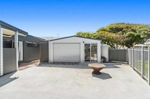 a patio with a bench in front of a house at Mini Beach Cottage - Seaspray Escape in Seaspray