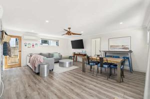 a living room with a couch and a table at Mini Beach Cottage - Seaspray Escape in Seaspray