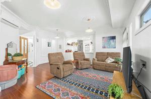 a living room with two chairs and a tv at Mini Beach Cottage - Seaspray Escape in Seaspray