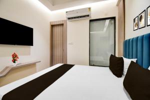a bedroom with a large bed and a tv at Collection O Bairhana Road Prayagraj in Prayagraj