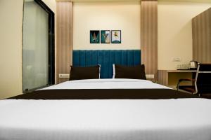 a bedroom with a large bed with a blue headboard at Collection O Bairhana Road Prayagraj in Prayagraj