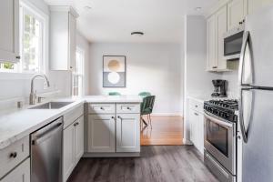 a kitchen with white cabinets and stainless steel appliances at Blueground Centennial BBQ nr Red Morton Park SFO-1855 in Redwood City